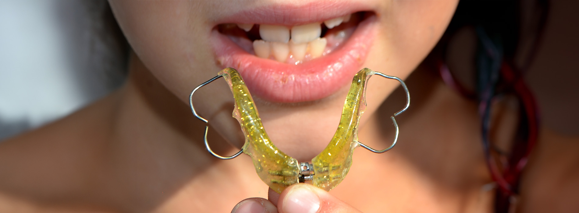 The image shows a person holding a yellow object near their mouth.