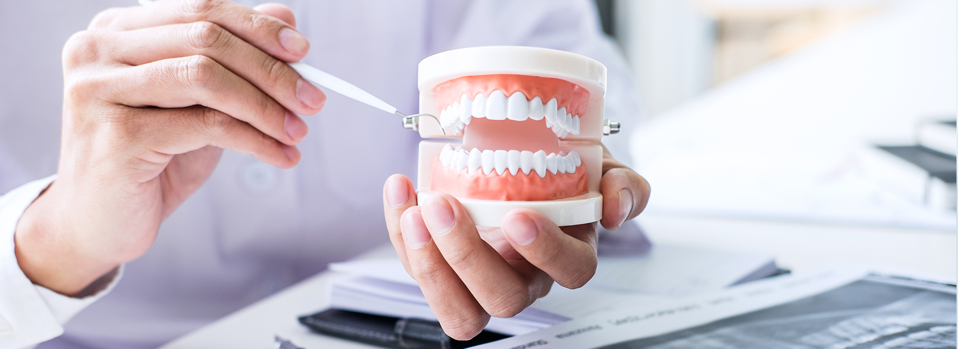 The image shows a person holding a toothbrush near their mouth while another person appears to be examining a document, with a focus on dental care and hygiene.